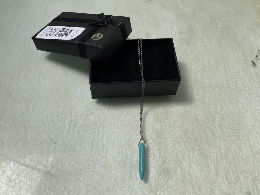 A TURQUOISE PENDANT MOUNTED ON A FINE CHAIN IN PRE