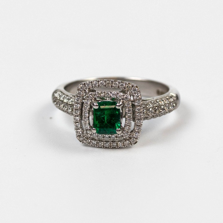 18ct White Gold 0.57ct Diamond and 0.40ct Emerald Double Halo and Shoulders Ring, Size M½, 2.3g.  Auction Guide: £650-£850 (VAT Only Payable on Buyers Premium)