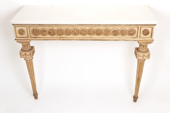 Pair of late 18th century Italian white painted parcel-gilt console tables, Neapolitan, white marble tops set upon frieze carved with guilloche pattern, raised by tapering fluted legs.