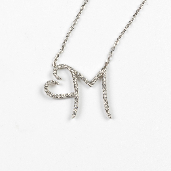 18K White 0.60ct Diamond Initial M Heart Pendant, 2.4x2.7cm, and Chain, 50cm, 3.8g.  Auction Guide: £900-£1,000