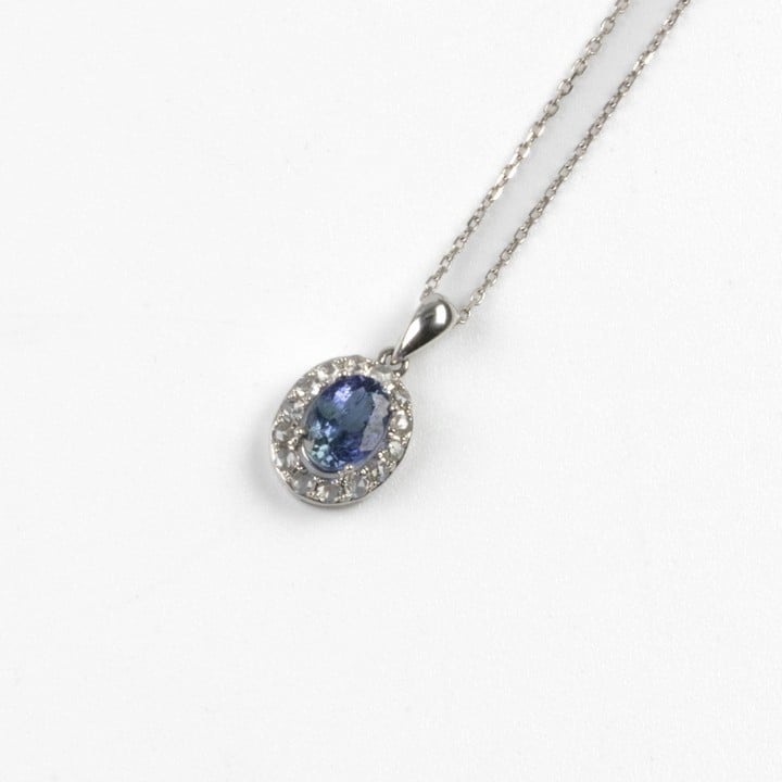 18K White 0.90ct Diffusion Treated Blue Sapphire and 0.20ct Halo Pendant and Chain, 50cm, 2.8g.  Auction Guide: £650-£850