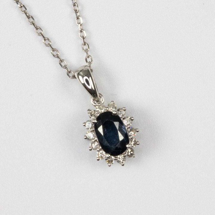 18K White 0.40ct Sapphire and 0.14ct Diamond Halo Pendant and Chain, 49cm, 2.3g.  Auction Guide: £450-£550