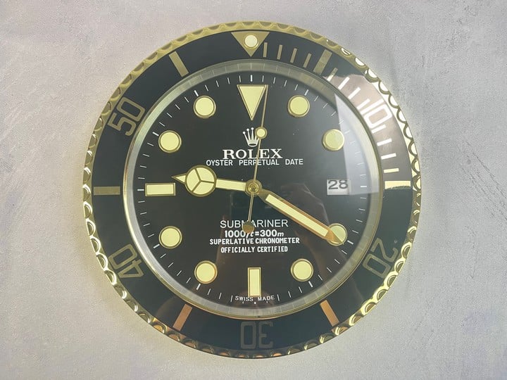 Black And Gold Wall Clock Not Rolex (VAT ONLY PAYABLE ON BUYERS PREMIUM)