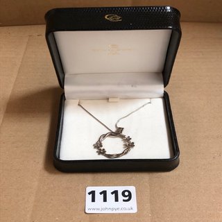 A SILVER COLOURED PENDANT AND CHAIN: LOCATION - CR