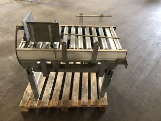 ROLLER CONVEYOR WITH BOTTLE PUSHING ATTACHMENT