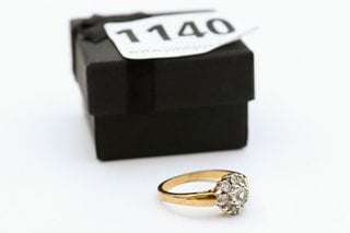 A YELLOW METAL RING SET WITH CLEAR STONES: LOCATION - CR