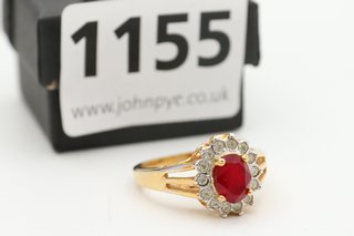 A YELLOW METAL RING SET WITH CLEAR AND RED STONES: LOCATION - CR