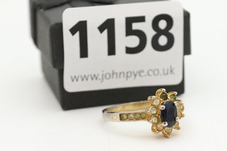 A YELLOW METAL RING SET WITH CLEAR AND BLACK STONES: LOCATION - CR