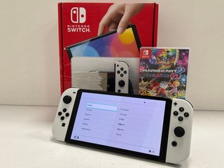 NINTENDO SWITCH OLED MODEL 64GB GAMES CONSOLE IN WHITE: MODEL NO HEG-001 (WITH BOX & ALL ACCESSORIES, TO INCLUDE MARIO KART 8 DELUXE GAME. MINOR COSMETIC IMPERFECTIONS ON BODY OF CONSOLE (PICTURED))