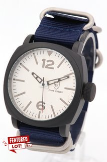 MEN'S FRANK SCHMIDT WATCH. FEATURING A WHITE PILOT DIAL, BLACK BEZEL AND CASE, W/R 3ATM. BLUE FABRIC STRAP. COMES WITH A PRESENTATION CASE: LOCATION - E0