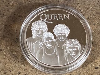 A QUEEN (BAND) COMMEMORATIVE SILVER COLOURED COIN: LOCATION - BR22