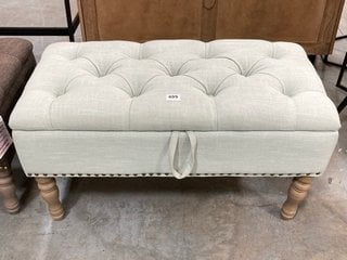 BUTTON TOP STYLE UPHOLSTERED SMALL END OF BED BLANKET BOX IN LIGHT AQUA GREEN FABRIC WITH ANTIQUE STUD AND LIGHT WOOD LEGS: LOCATION - D7