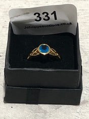 HALLMARKED GOLD COLOURED RING WITH BLUE STONE SET IN CELTIC DESIGN BASE