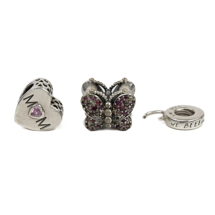 Pandora Silver Three Charms including Pink Stone Mum Heart, Clear and Pink Stone Pavé Butterfly, Spacer (faulty), total weight 6.1g (VAT Only Payable on Buyers Premium)