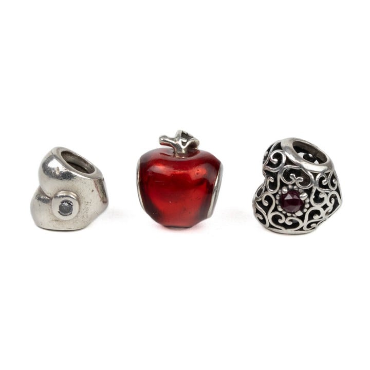 Pandora Silver Three Charms including Red Apple, Red Stone Filigree Heart, Clear Stone Heart, total weight 8.3g (VAT Only Payable on Buyers Premium)