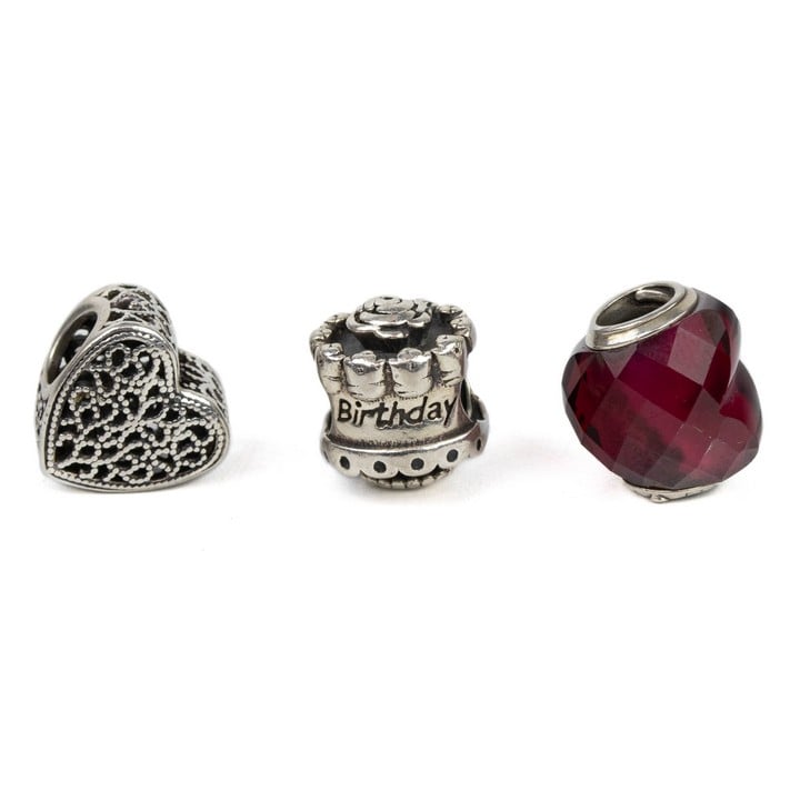 Pandora Silver Three Charms including Red Faceted Heart, Filigree Heart, Happy Birthday Cake, total weight 7.6g (VAT Only Payable on Buyers Premium)