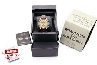 SWATCH MISSION TO SATURN BIOCERAMIC SPEEDMASTER MOONWATCH. FEATURING A MULTIFUNCTION OLIVE DIAL, WHITE MARKERS AND HANDS, BROWN BEZEL. OLIVE CASE, W/R 3ATM, BROWN FABRIC VELCRO STRAP. COMES WITH BOX